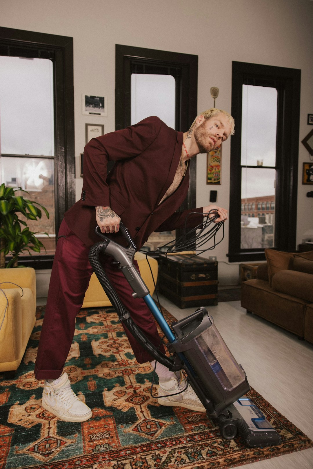 about-02 a-man-in-a-red-suit-is-using-a-vacuum-mrga-qbalgw