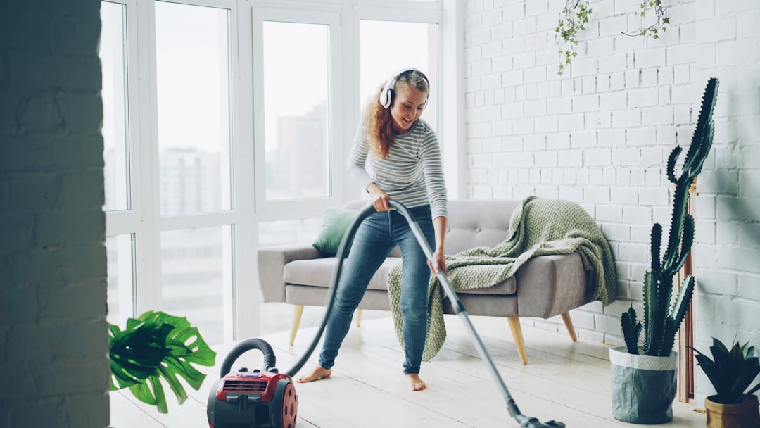 why-choose-us-03 Attractive young lady is dancing and singing listening to music through wireless headphones during housecleaning at home, girl is hoovering floor and enjoying tune.
